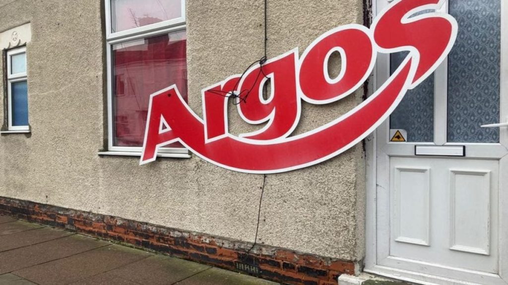 Hero of the Hour – Andy from Argos – Argos sign on Grimsby house – Grimsby resident takes with good humour someone attaching an Argos sign to his house whilst journalist reporting story of it goes all Miss Marple. Facebook group Angry People in Local Newspapers, GrimsbyLive.